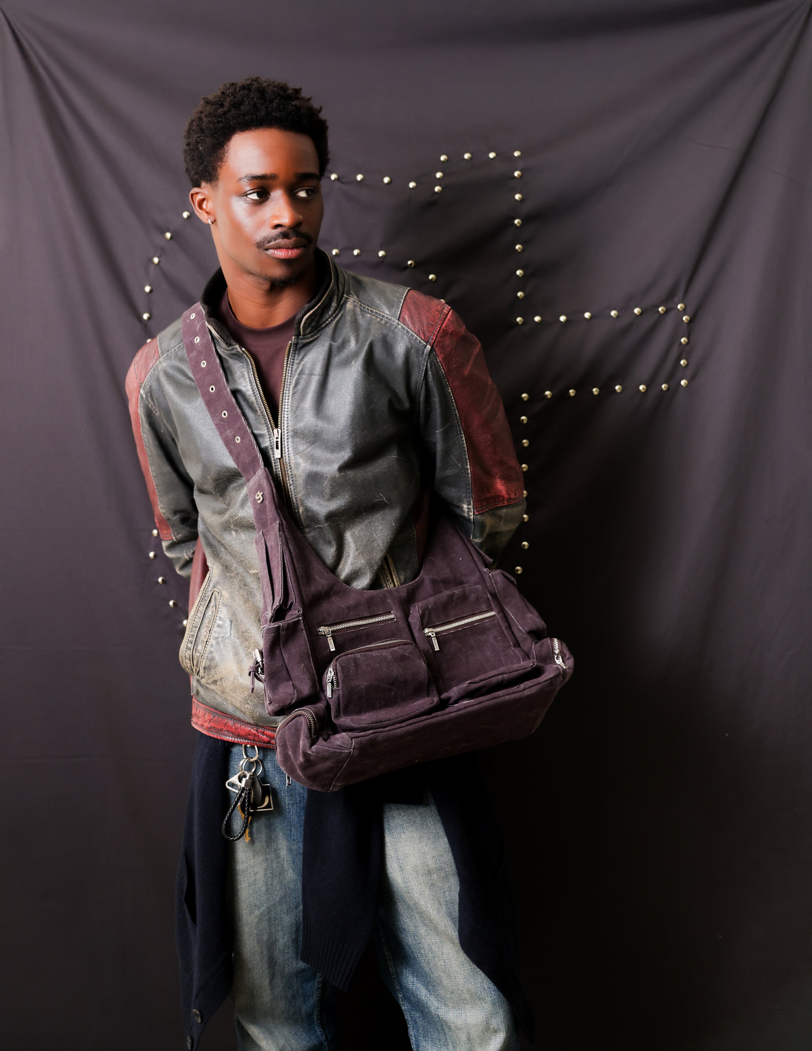 woman sitting on a chair holding a grey handbag with her leg poking out 